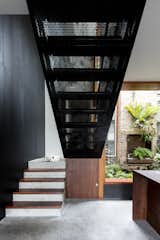 Staircase, Metal Tread, Wood Tread, and Concrete Tread Perforated black metal has also been used in the design of the staircase. 

  Photo 8 of 9 in A Dark Sydney Home Finds Light With a Unifying Expansion