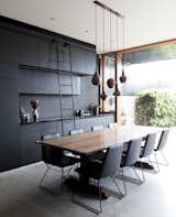 Dining Room, Chair, Concrete Floor, Pendant Lighting, Table, Storage, and Recessed Lighting The full-height sliding glass doors have been added to mediate the threshold between the garden and house. 

  Photos from A Dark Sydney Home Finds Light With a Unifying Expansion