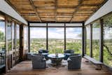 Living Room, Medium Hardwood Floor, Chair, Table, Bench, Recessed Lighting, Coffee Tables, and Rug Floor Extensive glazing provides ample natural light and panoramic views of the surrounding scenery.  Photos from An Old Texas Ranch Becomes a Spectacular Family Haven