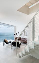 Living, Sofa, Coffee Tables, Chair, Rug, Ceramic Tile, Recessed, and Floor  A central staircase with perforated metal treads and risers allows natural light to filter down from the roof-deck level through the center of the home. 

  Living Ceramic Tile Recessed Rug Photos from Own This Sustainably Designed Malibu Beach House For $5.7M