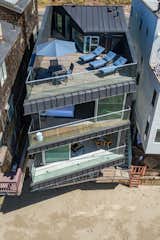 Standing-seam siding folds up from the street façade over the roofline to the roof deck, creating a seamless transition between wall and roof. 

  Photo 5 of 12 in Own This Sustainably Designed Malibu Beach House For $5.7M