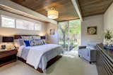 Bedroom, Carpet, Lamps, Floor, Chair, Ceiling, Bed, Dresser, and Night Stands The master suite has sliding doors that lead out to the exterior patio. 

  Bedroom Carpet Floor Night Stands Lamps Ceiling Photos from A Bay Area Eichler With Custom Updates Hits the Market at $1.29M