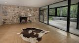 The living room features a natural flagstone inlay wall with a built-in fireplace juxtaposed against a row of windows.&nbsp;