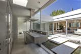 The modern, stainless-steel kitchen also fully opens to the atrium.