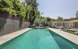 Outdoor, Trees, Large Pools, Tubs, Shower, Back Yard, Large Patio, Porch, Deck, Horizontal Fences, Wall, and Grass The spa-like pool is the centerpiece of the backyard.  Photo 14 of 17 in Fifty Shades Actor Jamie Dornan Lists His Midcentury Retreat at $3.2M