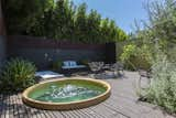 A jacuzzi is tucked away in the back corner of the yard.