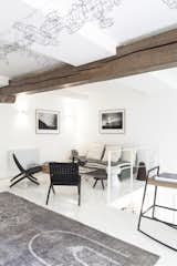 Living Room, Chair, Coffee Tables, Rug Floor, Sofa, Bench, and Light Hardwood Floor Floors have been covered by a thick coat of white paint. 

  Photo 7 of 14 in A Parisian Townhouse Is Reborn as a Luminous Art Gallery