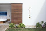 Outdoor, Gardens, Shower, Small, Grass, and Decking With the home being located just minutes from the beach, the outdoor shower from Kohler's Purist collection is a perfect spot to rinse off after excursions. 

  Outdoor Grass Shower Photos from A Dark Midcentury Becomes a Luminous Gem