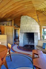 Living Room, Standard Layout Fireplace, Chair, Rug Floor, Table, and Wood Burning Fireplace The concrete block fireplace.  Photo 6 of 13 in The Iconic Home Frank Lloyd Wright Built For His Son Is Listed For $13M