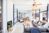 Living Room, Rug Floor, Sectional, Chair, Standard Layout Fireplace, Light Hardwood Floor, and Ceiling Lighting The tongue-and-groove ceiling has been painted a crisp white, helping the interiors to encompass a bright, airy feel. 

  Photos from Grab This Orange County Eichler For $1M