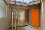 Exterior, Mid-Century Building Type, Wood Siding Material, Flat RoofLine, House Building Type, and Brick Siding Material A bright orange door adds a pop of color to the home.  Photo 11 of 77 in Love It or Hate It? Colorful Front Doors by Dwell from A Berkeley Midcentury With Jaw-Dropping Views Asks $945K