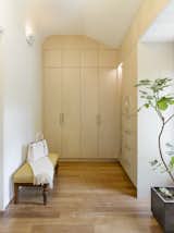 A large dressing room in the master suite shows off a uniquely customized built-in closet, which is perfectly inserted into the original curve of the ceiling.  Photo 17 of 18 in An Elegant Edwardian Home Is Treated to a Thoughtful Revamp