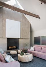Rich, barn-like wooden beams punctuate the sleek, airy interiors, adding texture and character. Pops of color from the bright pink sofas, combined with the hand-knotted rugs, add a sense of luxury to the polished concrete floors.&nbsp;
