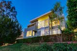 Exterior, Mid-Century, Concrete, Glass, Metal, Flat, Metal, and House A view of the home at night. 

  Exterior Metal House Metal Flat Mid-Century Photos from Own This Charming 1941 Midcentury in L.A. For $1.9M