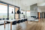 Dining Room, Chair, Table, Pendant Lighting, Light Hardwood Floor, Ribbon Fireplace, and Rug Floor Tom Dixon's Beat pendant lighting hangs over the dining table.   Photo 10 of 110 in Fire by Casey Tiedman from An Interior Designer’s Utah Abode Blends Mountain Living With Scandinavian Style