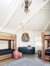 Bedroom, Ceiling, Bed, Rug, Dresser, Pendant, and Concrete Reconfiguring the home from three bedrooms to five bedrooms ensured that there would be not only enough space for the family of six, but also for the guests they love to entertain on the weekends.   Bedroom Pendant Concrete Dresser Ceiling Photos from A Delicate Renovation Revives a ’70s Beach House in Northern California