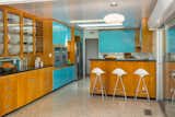 Kitchen, Terrazzo Floor, Ceiling Lighting, Wood Cabinet, Colorful Cabinet, Refrigerator, and Wall Oven Although the kitchen has been updated for modern living, it still maintains an authentic midcentury sense of style. 

  Photos from Step Back in Time in This Midcentury Now Asking $1.4M