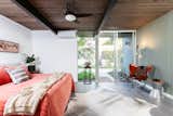 Bedroom, Bed, Rug, Ceiling, Night Stands, Floor, Lamps, Porcelain Tile, and Chair The master bedroom has French doors which lead to the outside.  Bedroom Chair Bed Ceiling Floor Photos from An Updated Eichler With an Indoor-Outdoor Master Bath Seeks $1.15M