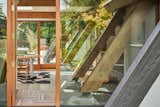 Dining, Chair, Concrete, Table, Rug, Recessed, and Terrazzo A view from the outside highlights the home's timber frame.   Dining Chair Recessed Terrazzo Table Photos from Before & After: An Expanded Wedge-Shaped Abode Flaunts its Midcentury Roots