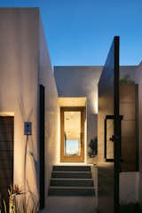 Doors, Exterior, Swing Door Type, and Wood The home is clad in stucco, which is an extremely fire-resistant material. The front door is made from mahogany, which is durable and matches the gate.  Photos from Architect Abeer Sweis Shares Fire-Resistant Building Strategies