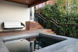 A lower-level patio with benches and a generously sized spa allows the homeowner to enjoy the view while entertaining company. The stairs are made from naturally fire-resistant ipe wood.