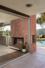 The&nbsp;corner fireplace has a barbecue feature on the exterior, overlooking the pool.&nbsp;