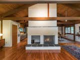 At a home designed in the 1980s in Connecticut, the central space of the home is occupied by a hearth with an adjacent space for firewood storage. Together, they form a symmetrical composition.
