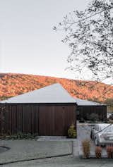 The roof creates a dialogue with the surrounding landscape through multiple sloped planes, irregular lines, and an absence of overhangs. The home's form appears to change according to one's angle of approach.