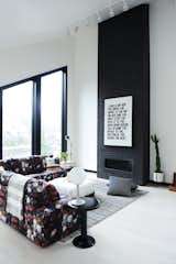 The open-plan living space is anchored by a black brick fireplace with a sleek modern profile.&nbsp;Muddox makes the commercial wire-cut thin&nbsp;bricks in ebony with liquid black added to the mortar mix. The Studio Floor Lamp is from Schoolhouse.&nbsp;