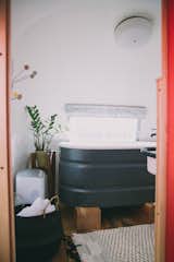 The trailer is hooked up to running water, however it features a waterless composting toilet from Separett. In the winter, there is on-demand hot water for luxurious bathing. The deep, repurposed stock tank tub is one of the couple's favorite things about the renovation. 