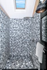 The luxury bathroom boasts a stylish glass-tiled shower and a solar-vented skylight.
