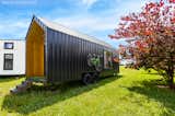 The Roost26 tiny house features a lightweight, black AG metal roof and facade with a "detachable garden" on one side and bike racks on the other.&nbsp;