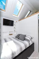 The bedroom features a retracting Apple TV and additional storage space. A 25-gallon fresh water tank lies beneath the bed.