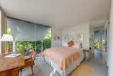 The bedroom features expansive windows.