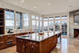 The gourmet kitchen features a large center island with a spacious breakfast bar and top-of-the-line appliances. Extensive glazing keeps the space bright and provides breathtaking views of the surroundings.&nbsp;