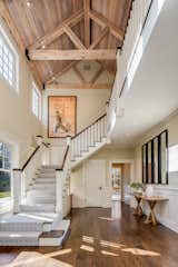 Stairs lead from the entry to the upper level with the bedrooms. The wood-paneled, vaulted ceiling adds warmth to the double-height space. 