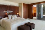 The master suite features wood paneling and extensive glazing, in keeping with the design of the home.