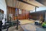 The wood-paneled garage is currently set up as a home gym and a play area.  