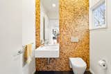 This updated bathroom features a fully tiled wall. 