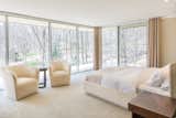 The master suite is located in a corner of the home and features floor-to-ceiling glass windows.