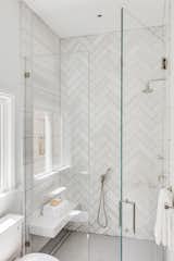 The stylish glass-enclosed shower features two contrasting types of tile.&nbsp;
