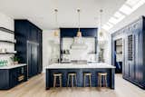 The main level features a bold blue kitchen illuminated by skylights.