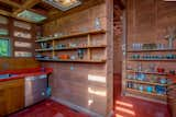 The kitchen has exposed concrete block walls and open shelving.&nbsp;