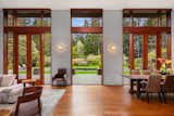 Full-height French doors topped with clerestory windows flood the open space with natural light. 