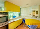 The kitchen features original, bright yellow St. Charles cabinetry.