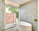 Even the bath has outdoor access. The tiles echo the pattern on the brise soleil.