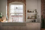The arched sconce, inspired by Allied Maker’s contour light, was custom-crafted to perfectly fit the kitchen window. The brass faucet is by Waterworks. The sink and countertop are both custom concrete designs by JHID which were fabricated in Oregon by Cement Elegance. 
