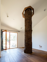 In order to waterproof the second bedroom with the tree, the owners consulted with treehouse builders. Ultimately, they decided that the best solution was to hire a tailor to fashion a skirt and a collar out of sailboat material. "It ended up being the easiest part of building this house," shared the owner.&nbsp;