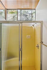 The second bathroom has clerestory windows and features cheery, yellow tiles. It is from the original 1958 construction.&nbsp;