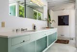 The terrazzo-floored master bath features cabinetry painted in Corbusier's Ceruleum Pale. The millwork incorporates sliding Factro-Lite glass panels.&nbsp;